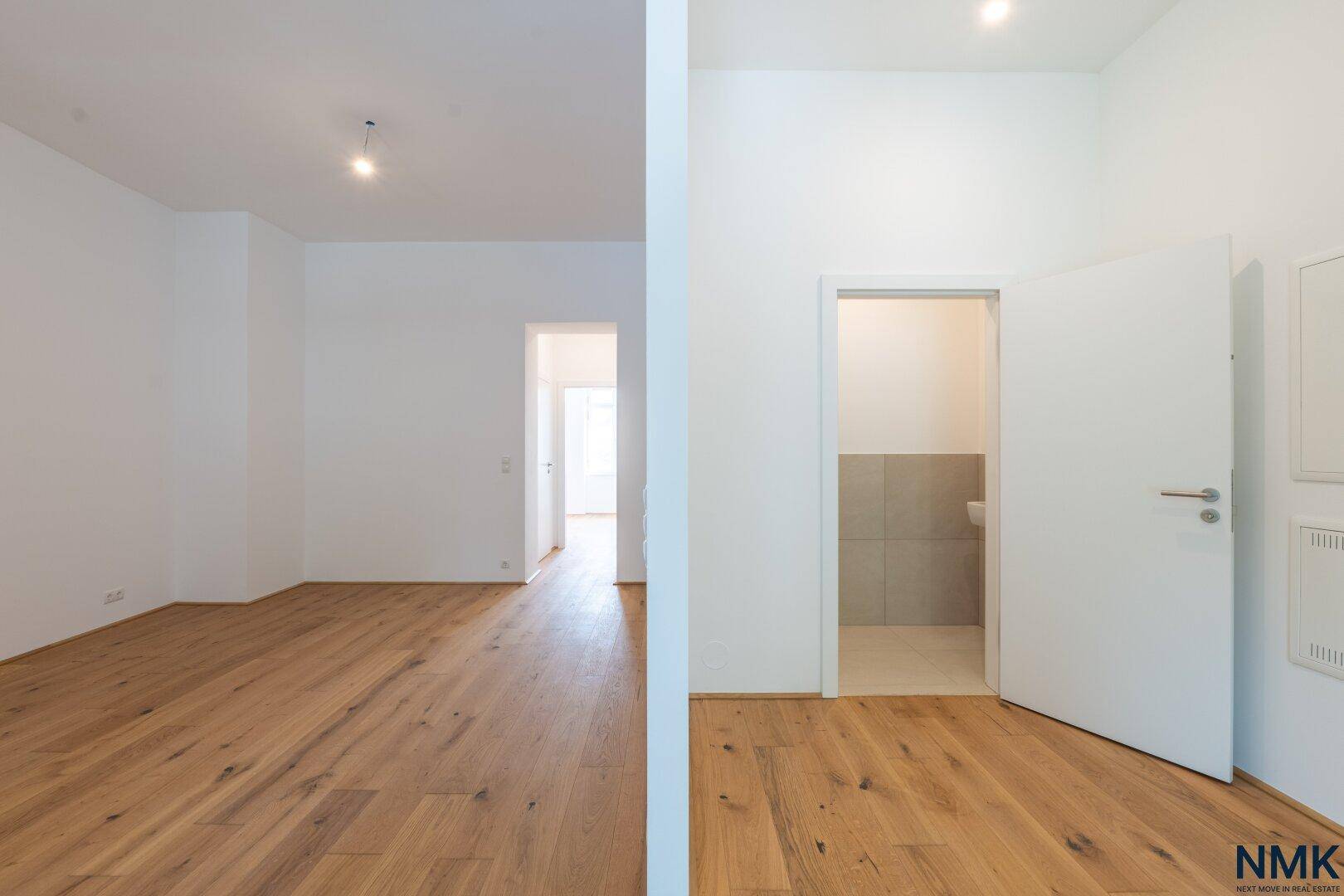Heller Flur mit Holzboden und Zugang zu einem separaten Gäste-WC.