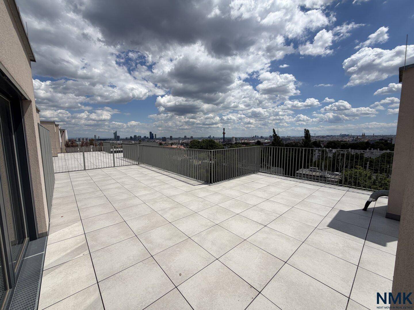 Geräumige, unmöblierte Dachterrasse mit Fliesenboden und Panoramablick auf die Stadt.