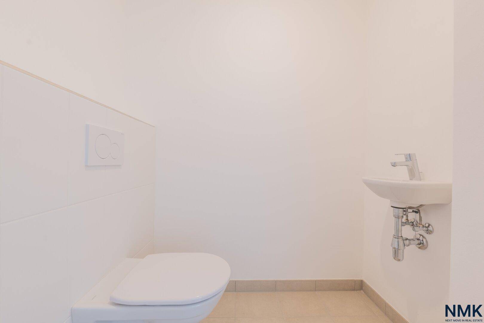 Kleines Gäste-WC mit wandhängender Toilette und einem kompakten Waschbecken.