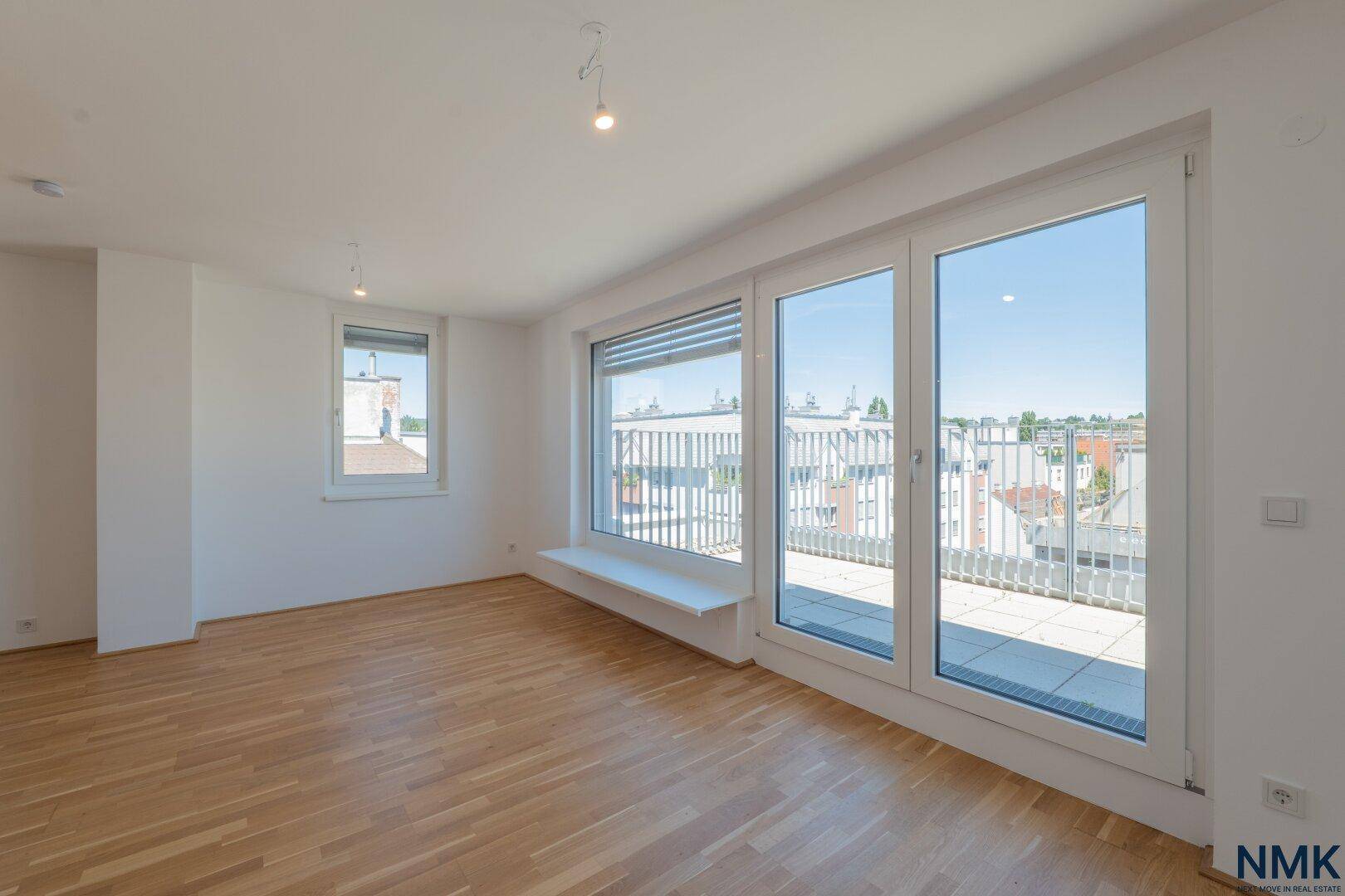 Heller Wohnbereich mit großen Glasfronten, die Zugang zur Terrasse und viel Tageslicht bieten.