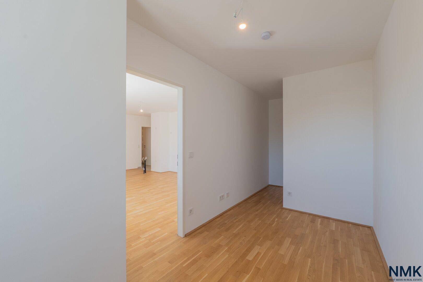 Heller Flurbereich mit Parkettboden, der zu weiteren Räumen der Wohnung führt.