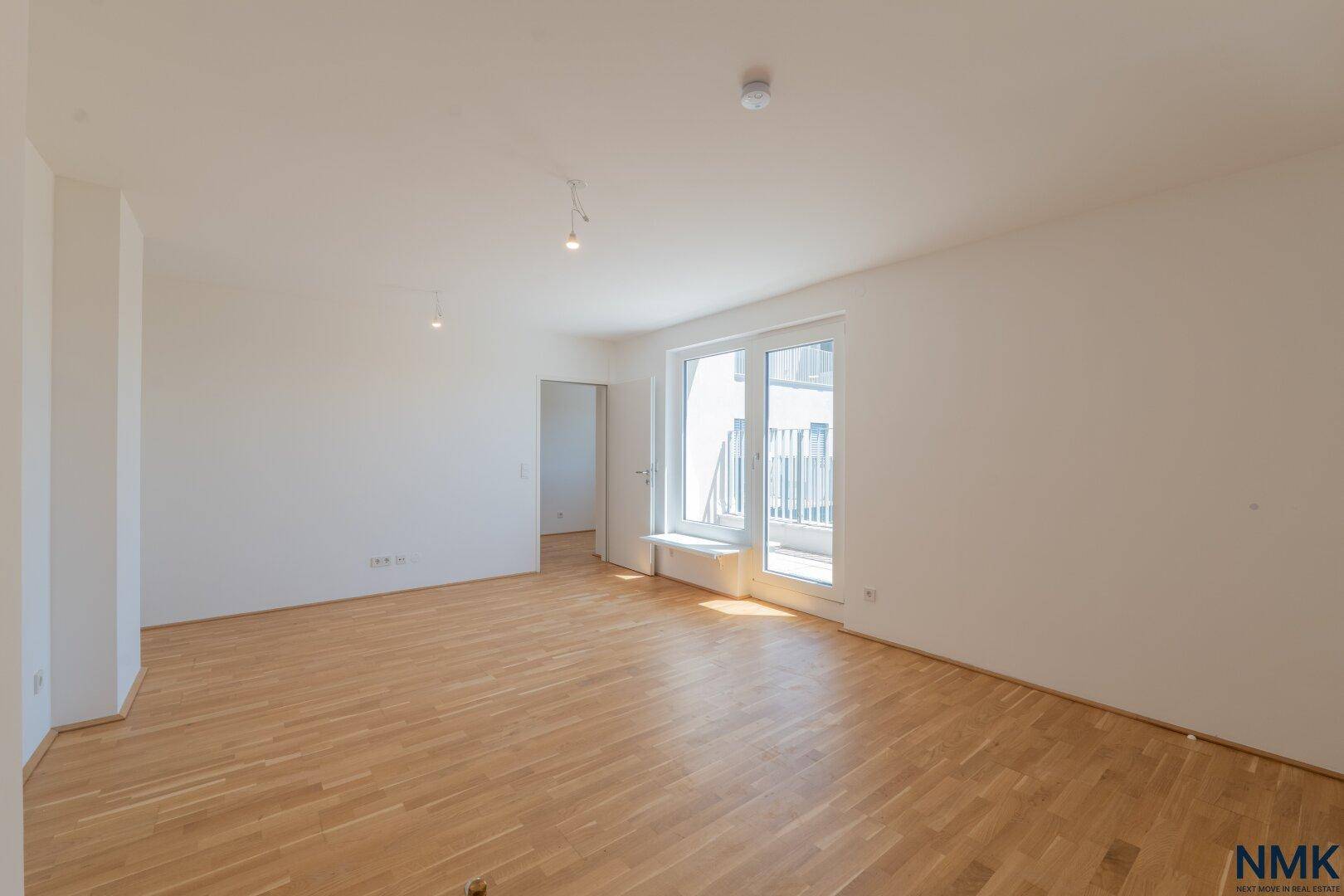 Weitläufiger, lichtdurchfluteter Raum mit Parkettboden und großen Fenstern, ideal für individuelle Gestaltung.