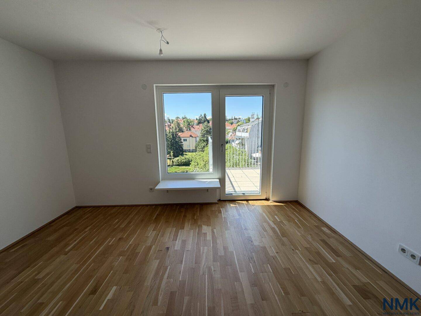 Geräumiger Raum mit Parkettboden und großen Fenstern, die viel natürliches Licht hereinlassen.