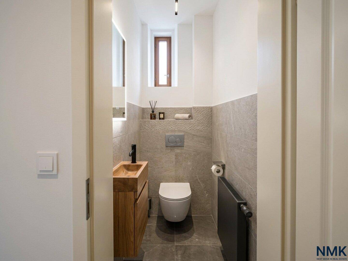 Modernes Gäste-WC mit Holzwaschtisch, wandhängender Toilette und eleganten grauen Fliesen.