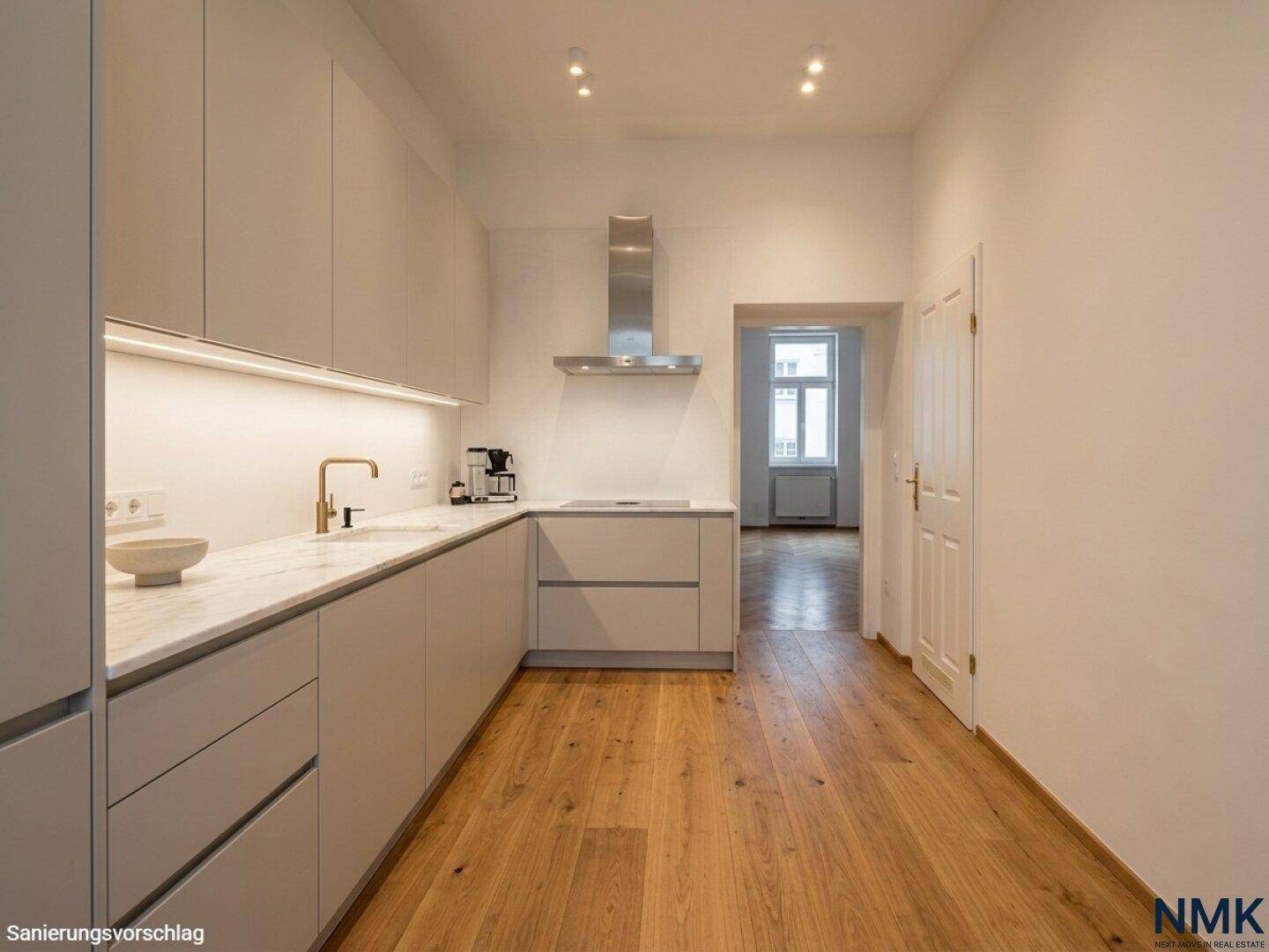 Moderne Küche mit hellgrauen Schränken, Holzfußboden und Dunstabzugshaube.