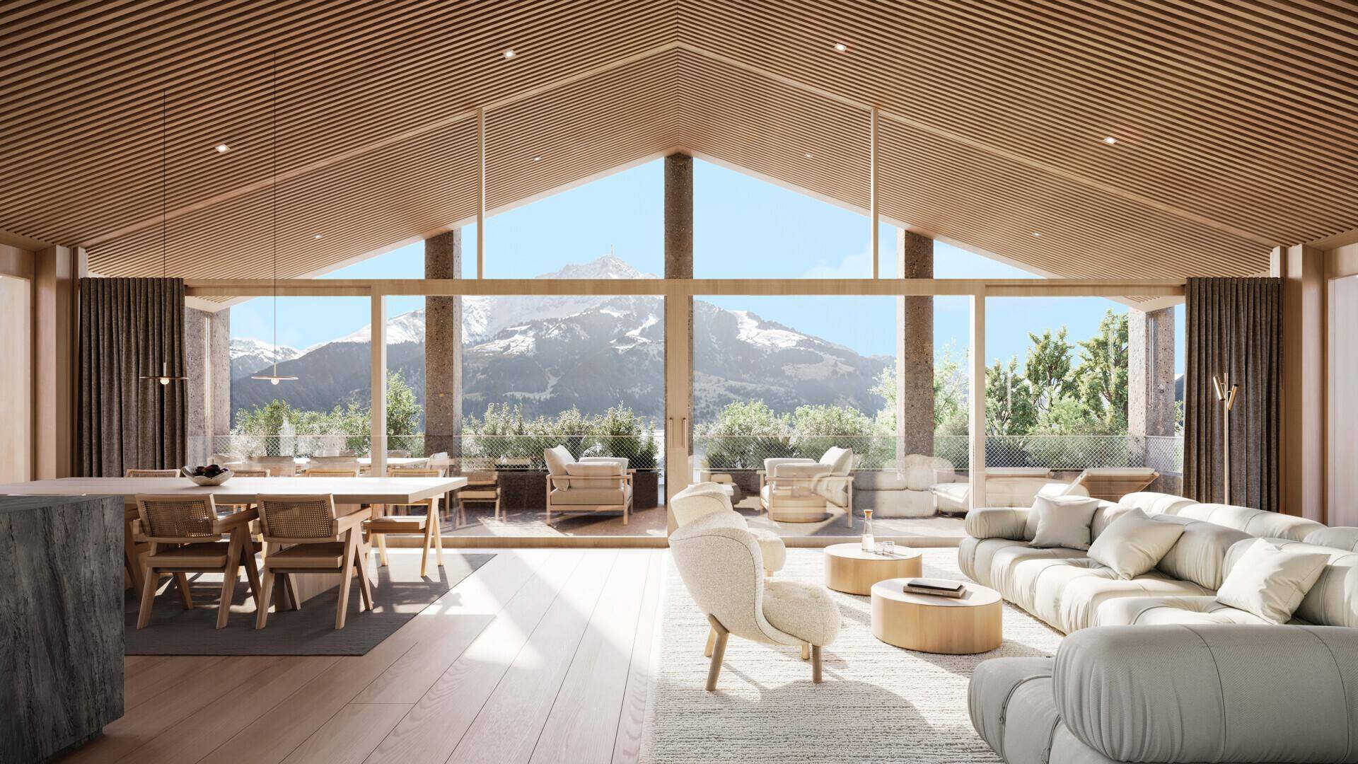 Lichtdurchfluteter Wohn-Essbereich mit hohen Decken, Holzelementen und Panoramablick auf die Berge.
