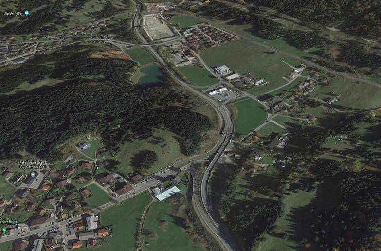 Dreidimensionale Luftaufnahme der Landschaft mit Straßen, Gebäuden und bewaldeten Hügeln.
