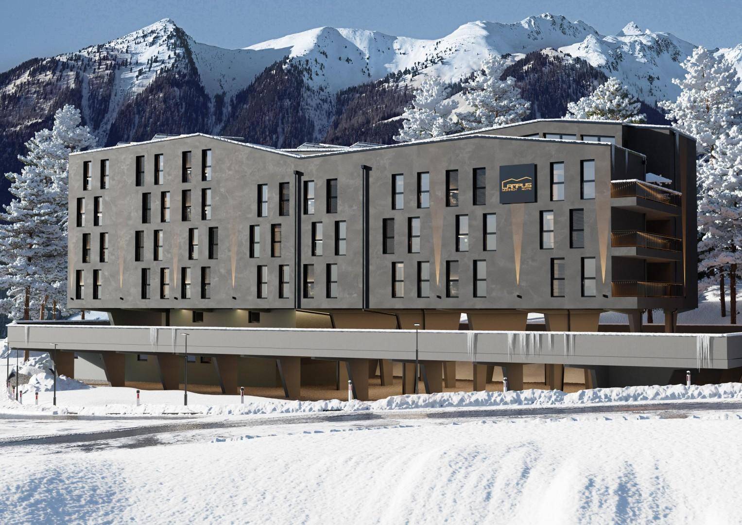 Modernes Gebäude in alpiner Landschaft mit schneebedeckten Bergen im Hintergrund.