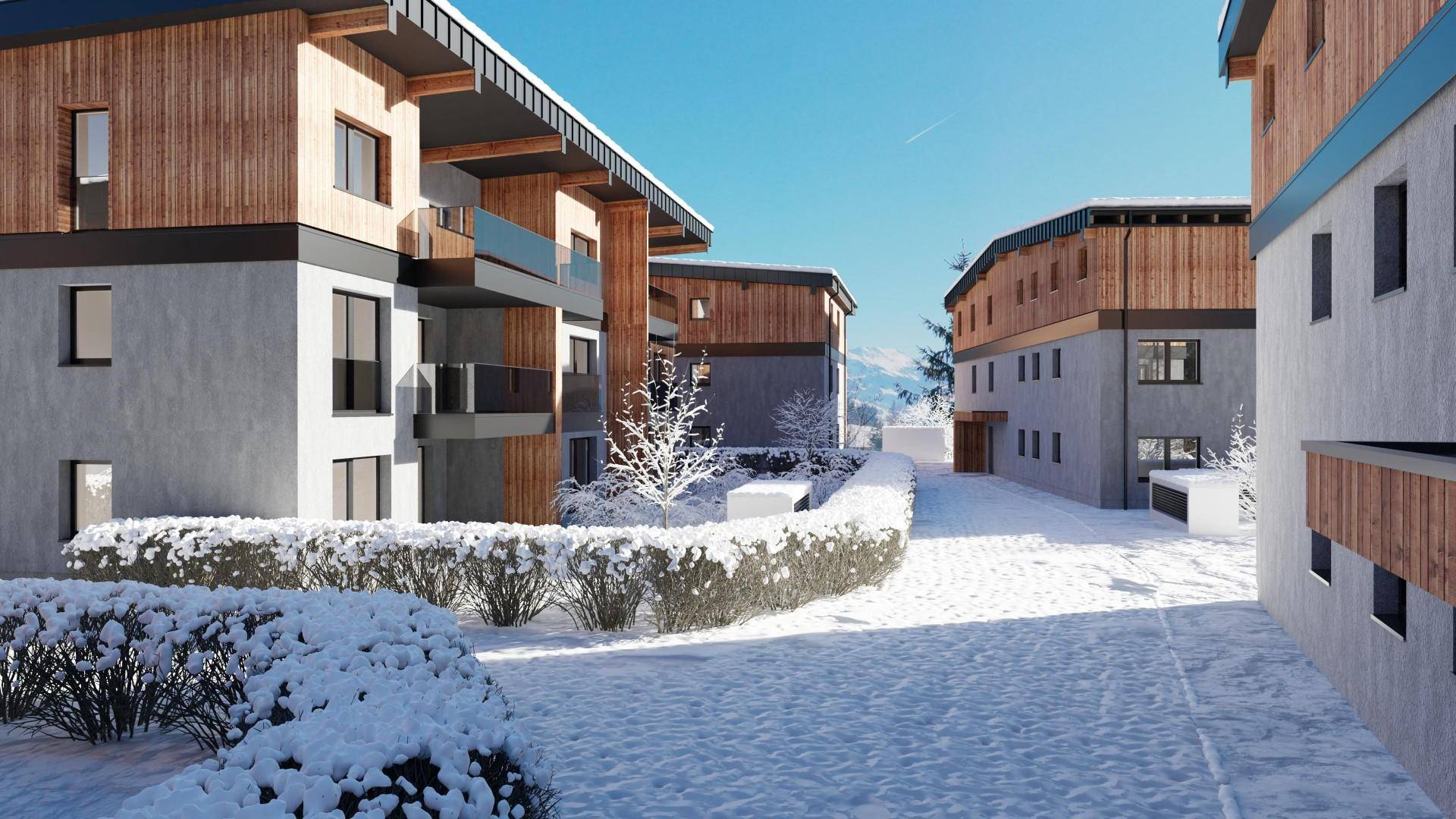 Moderne Gebäude mit Holzfassaden und Balkonen in verschneiter Berglandschaft.
