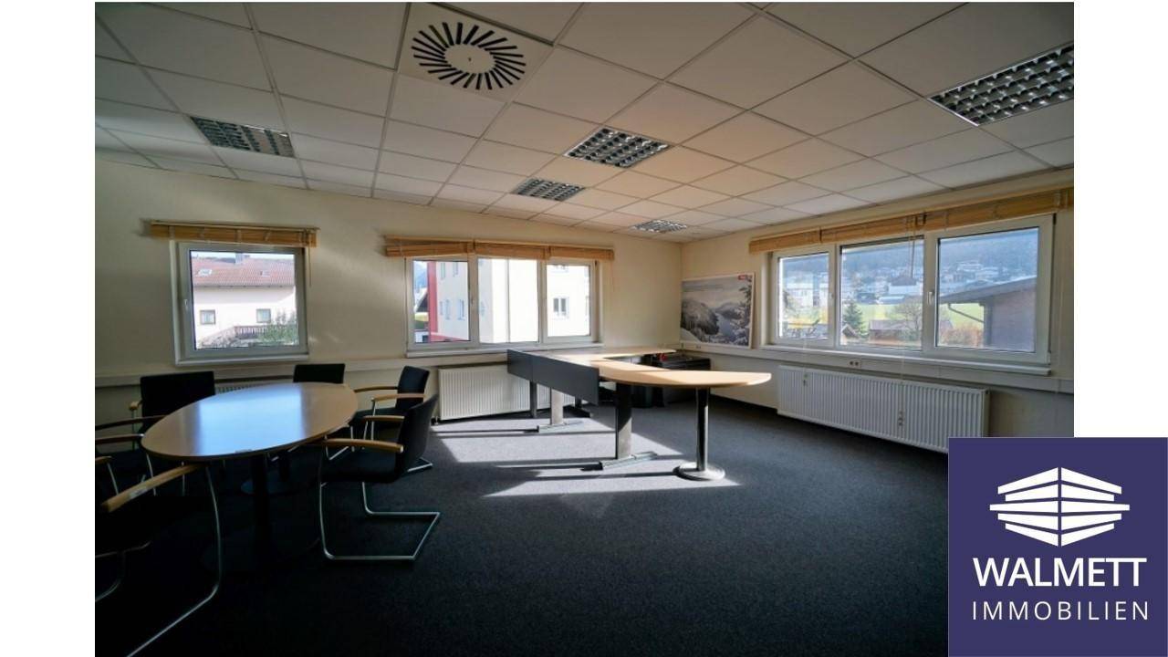 Konferenzraum mit Teppichboden, großen Fenstern und Heizkörpern, ausgestattet für Besprechungen.