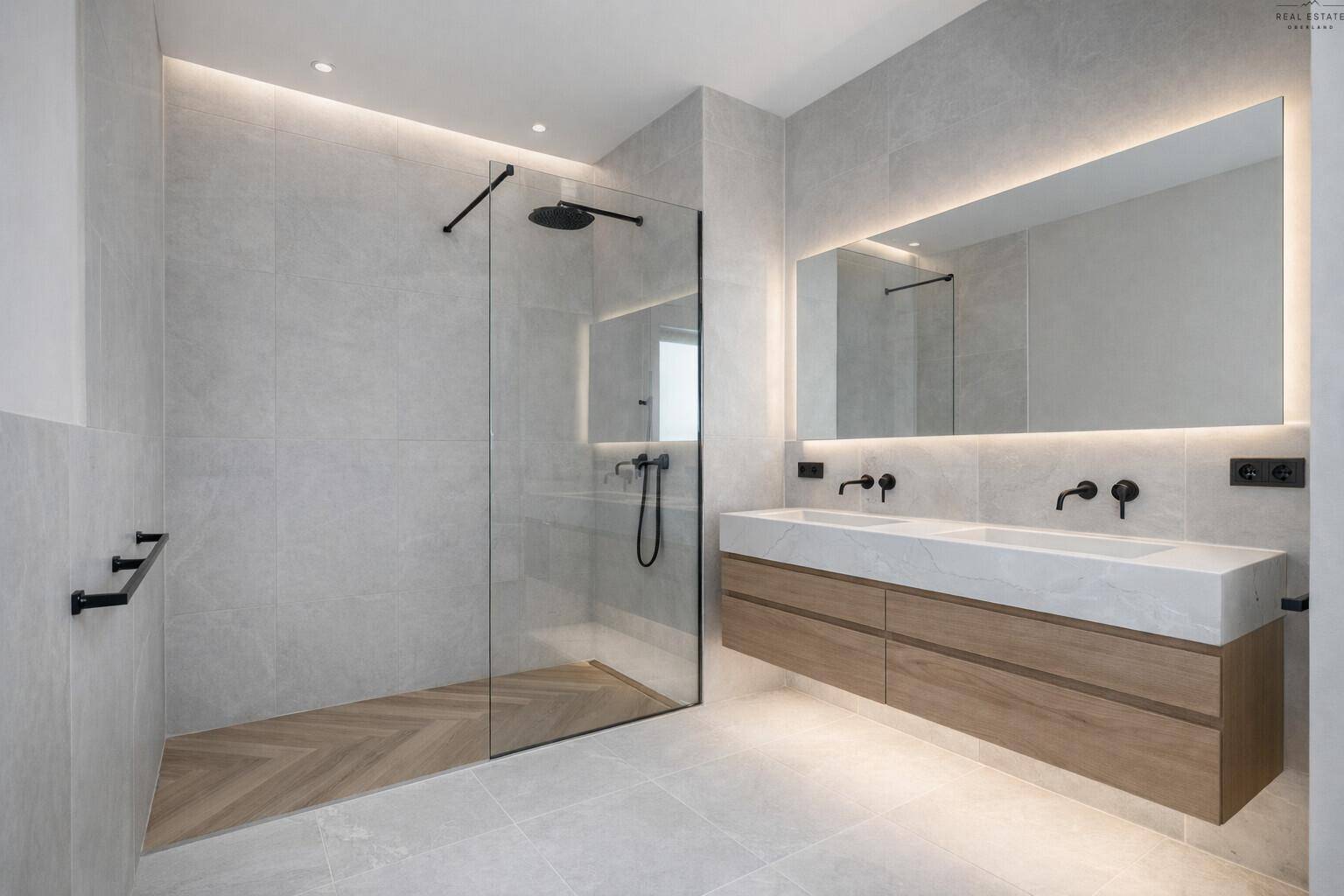 Modernes Badezimmer mit Doppelwaschbecken, großer begehbarer Dusche und indirekter Beleuchtung.