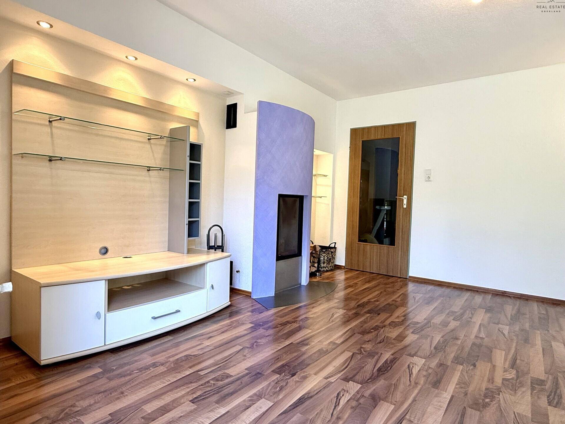 Wohnzimmer mit Laminatboden, stilvollem Kamin und einem modernen TV-Möbel mit Ablagen.