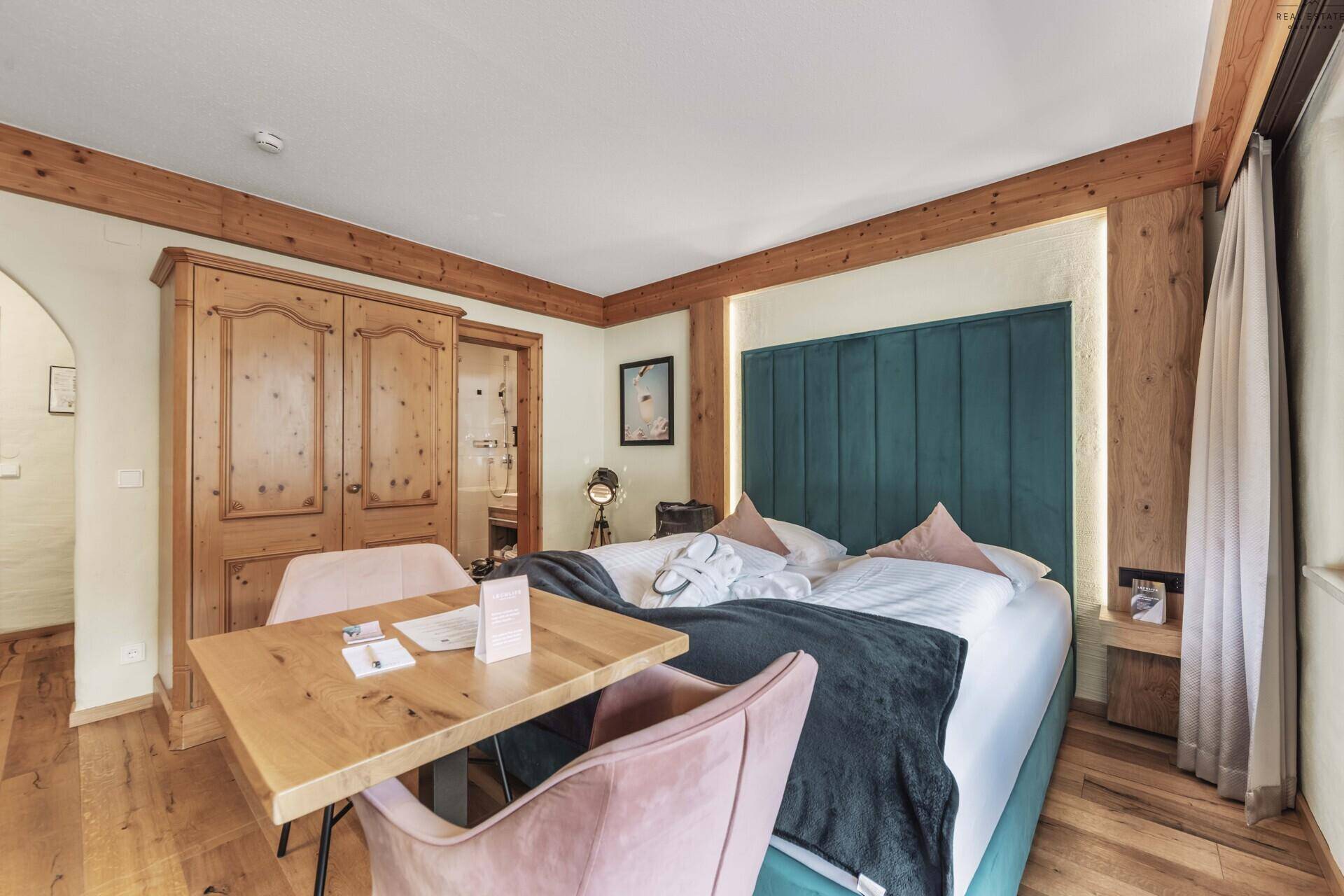 Komfortables Schlafzimmer mit Doppelbett, Holzboden und integrierten Holzschränken.