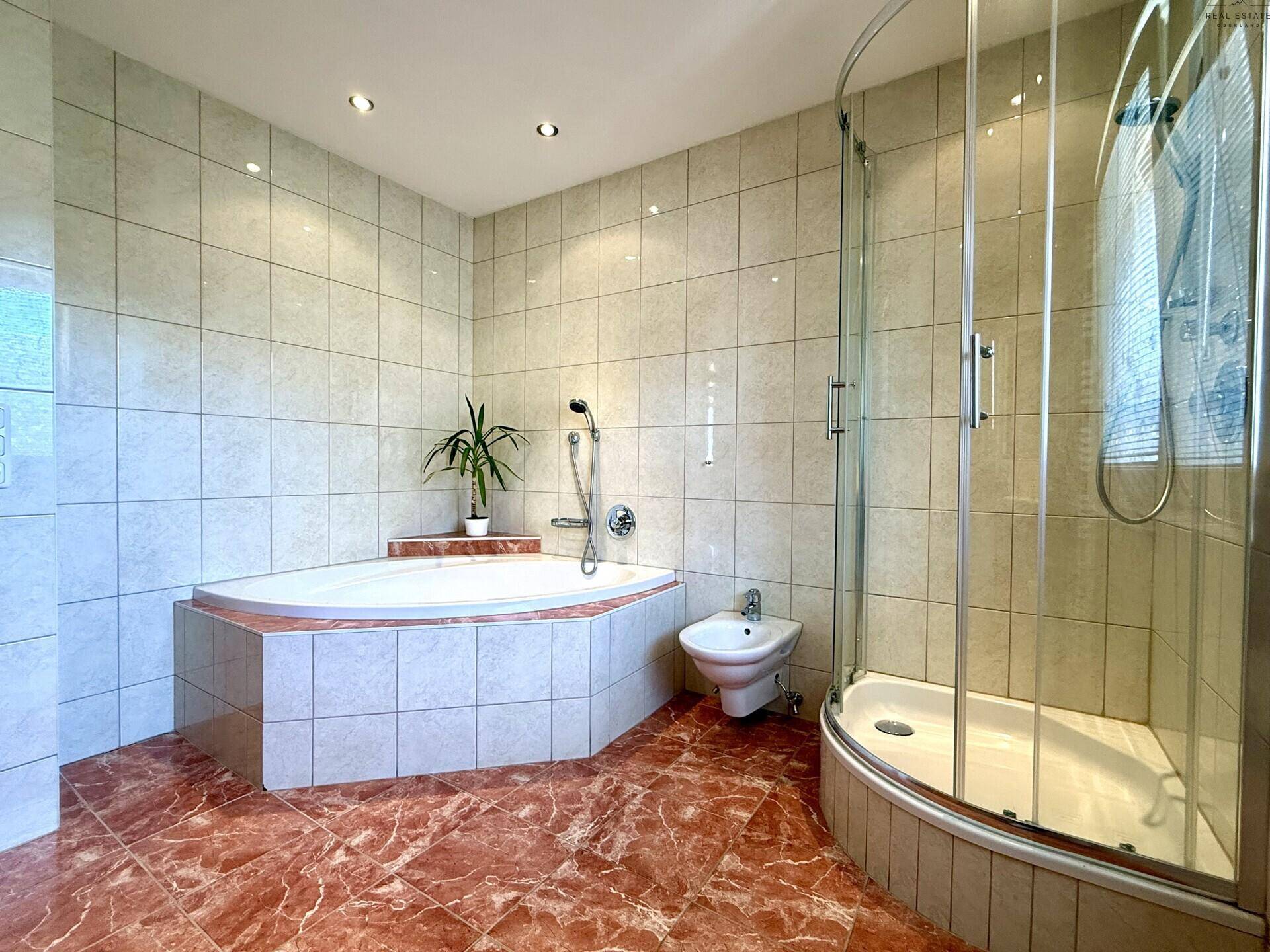 Badezimmer mit Eckbadewanne, Duschkabine, Bidet und gefliestem Boden für umfassenden Komfort.