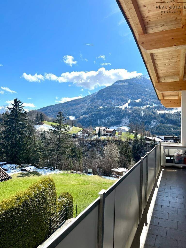 Balkon mit Bergblick und grüner Umgebung, ideal zum Entspannen im Freien.