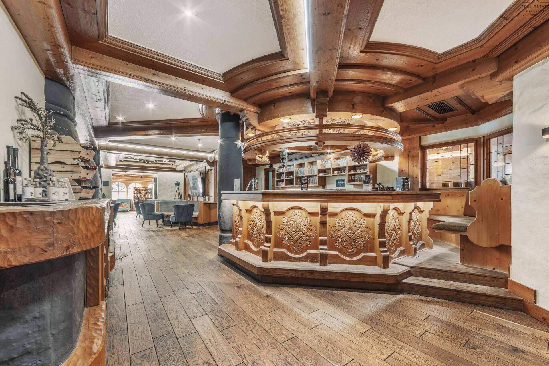 Elegante Bar mit aufwendigen Holzschnitzereien, Holzboden und gemütlicher Atmosphäre.