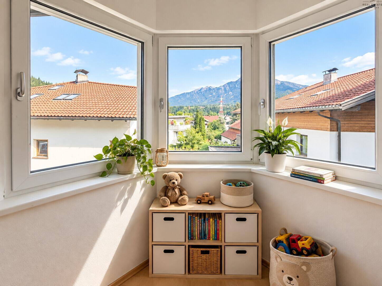 Heller Erkerbereich mit großen Fenstern, Bergblick und kleiner Spielecke.