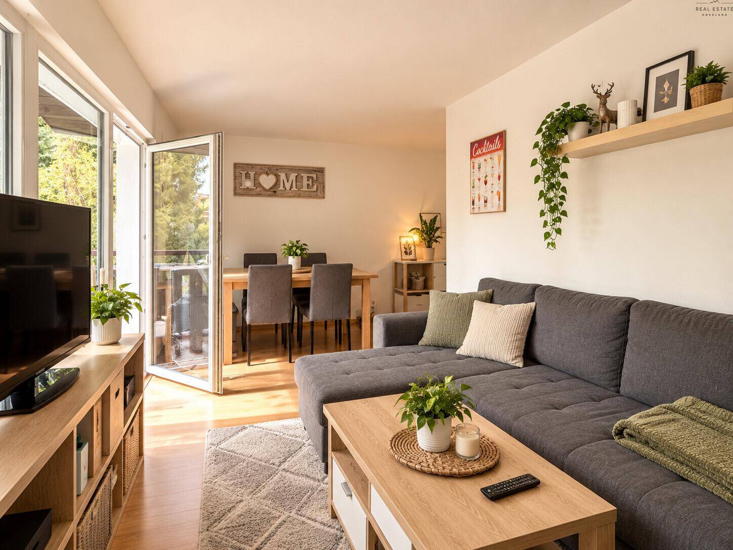 Gemütlicher Wohnbereich mit großem Ecksofa, Couchtisch und Zugang zum Balkon.
