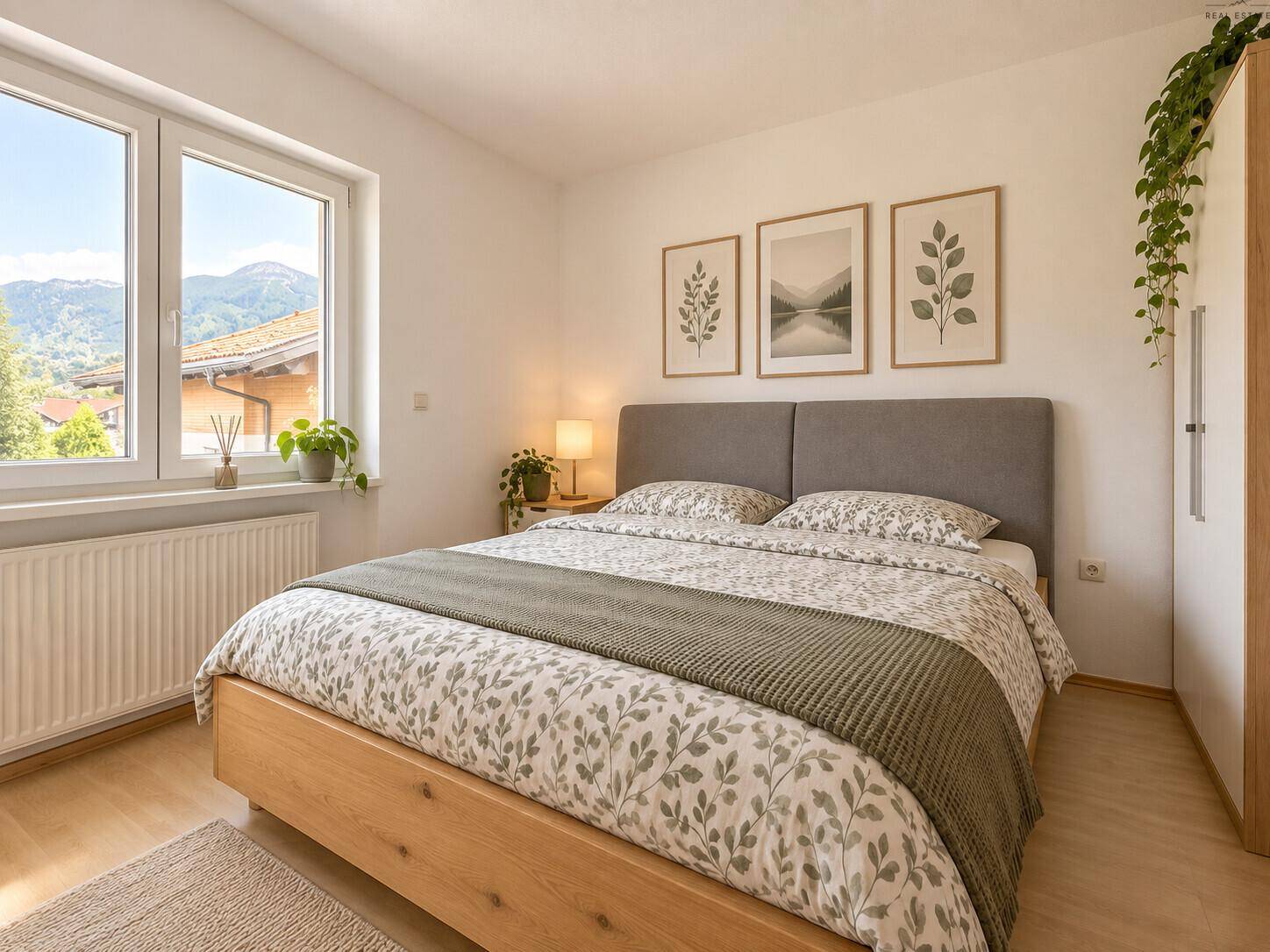 Helles Schlafzimmer mit Holzbett, Laminatboden und Blick auf die Berge.