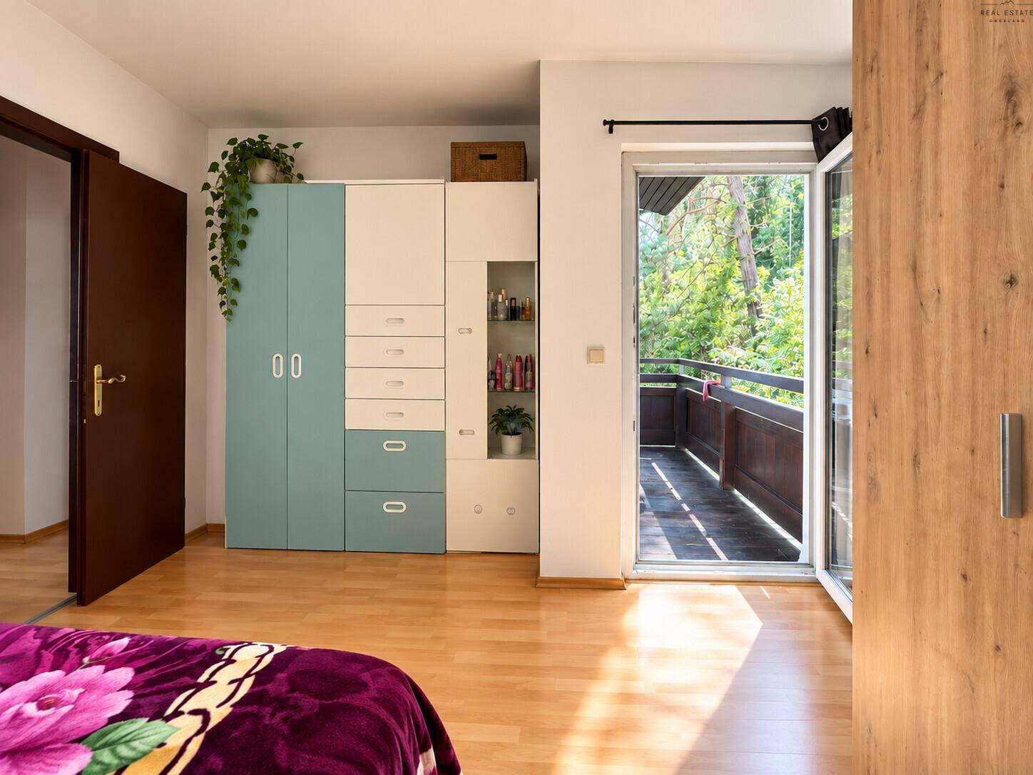 Schlafzimmer mit farbenfrohem Kleiderschrank und Zugang zum Balkon.
