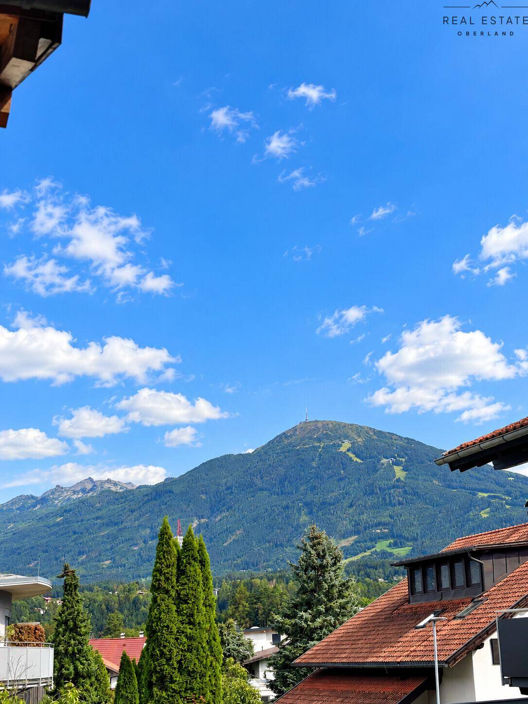 Panoramablick auf die Berge und die umliegende Landschaft unter blauem Himmel.
