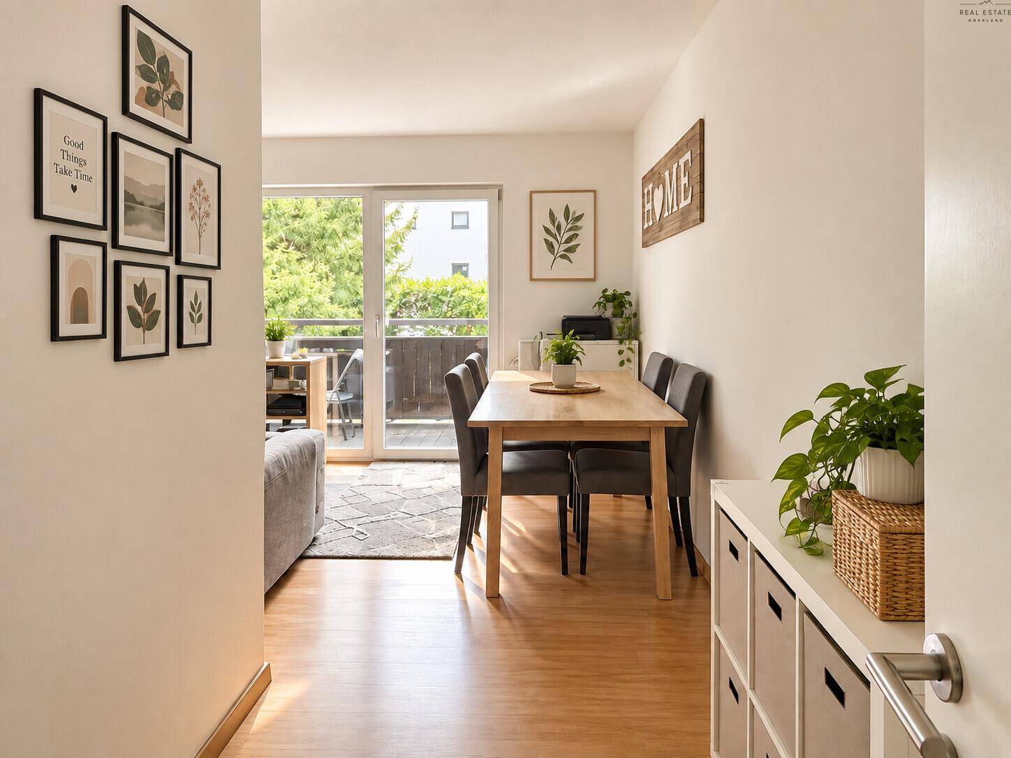 Offener Wohn- und Essbereich mit Holztisch, Sofa und Zugang zu einem Außenbereich.