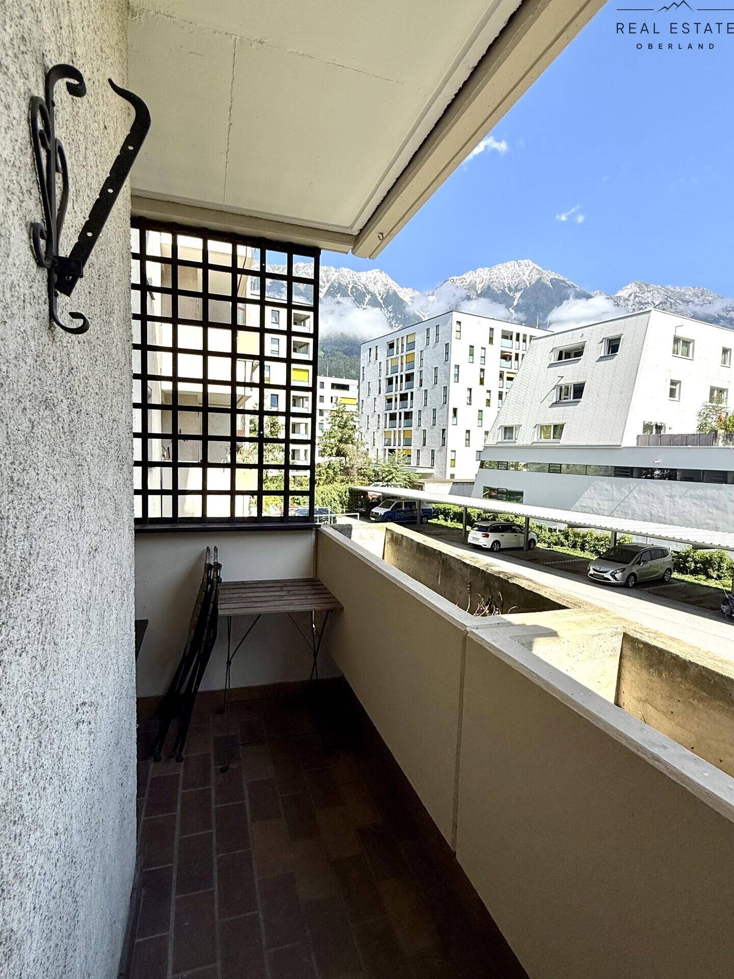 Balkon mit Bergblick und Blick auf umliegende Gebäude.