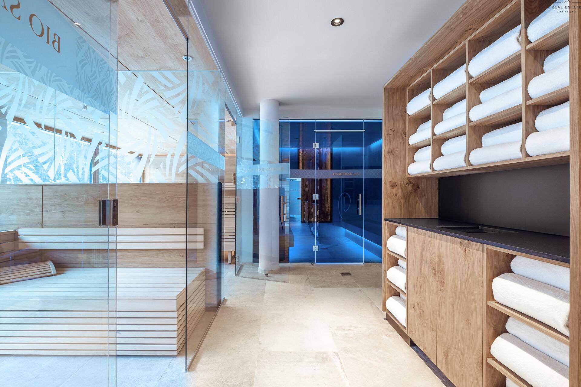 Heller Wellnessbereich mit Bio-Sauna, Handtuchregalen und modernem Design.