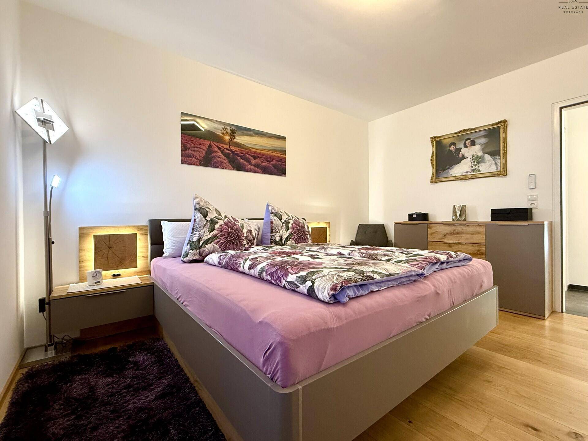 Helles Schlafzimmer mit bequemen Doppelbett, Holzboden und moderner Einrichtung.