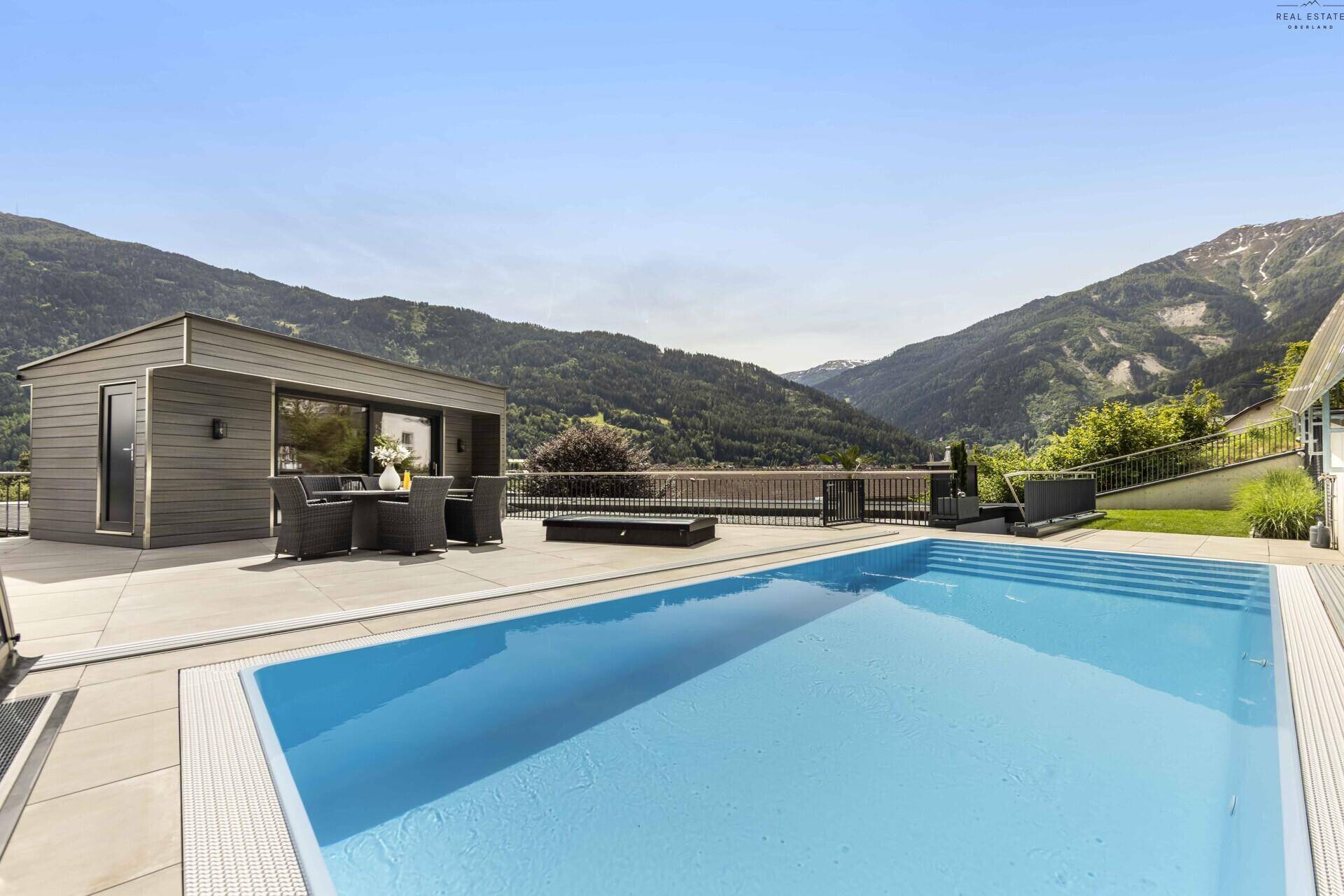 Großzügiger Außenbereich mit Pool und Essbereich, umgeben von einer malerischen Berglandschaft.