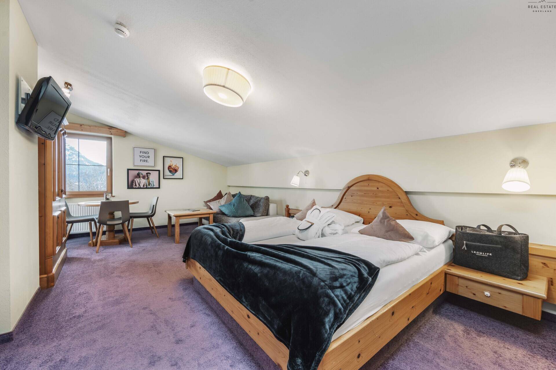 Geräumiges Schlafzimmer mit Doppelbett, Sitzbereich und Bergblick.