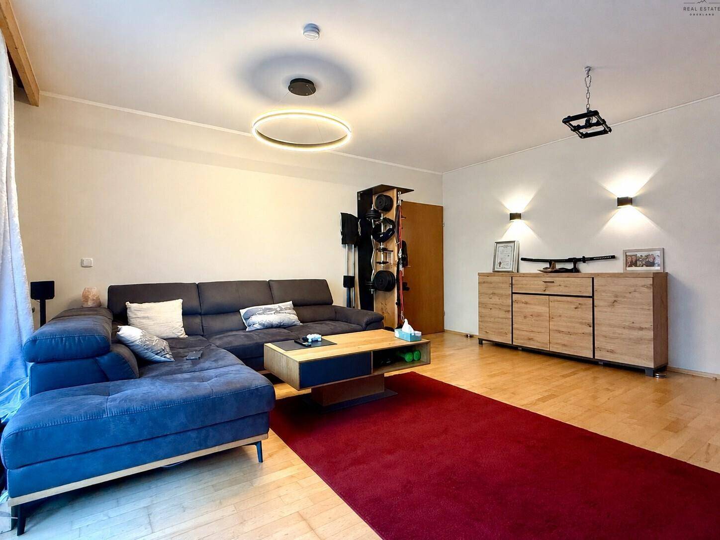 Helles Wohnzimmer mit bequemer Sitzecke, Holzboden und stilvoller Einrichtung.