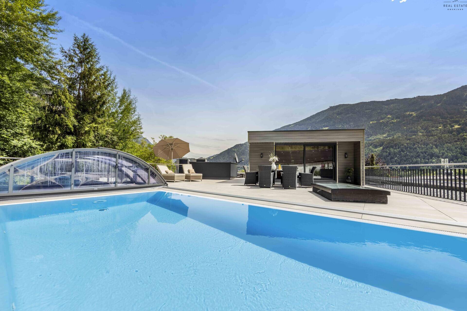 Sonniger Terrassenbereich mit Pool, Liegestühlen und Essgruppe, perfekt für Entspannung und Unterhaltung.