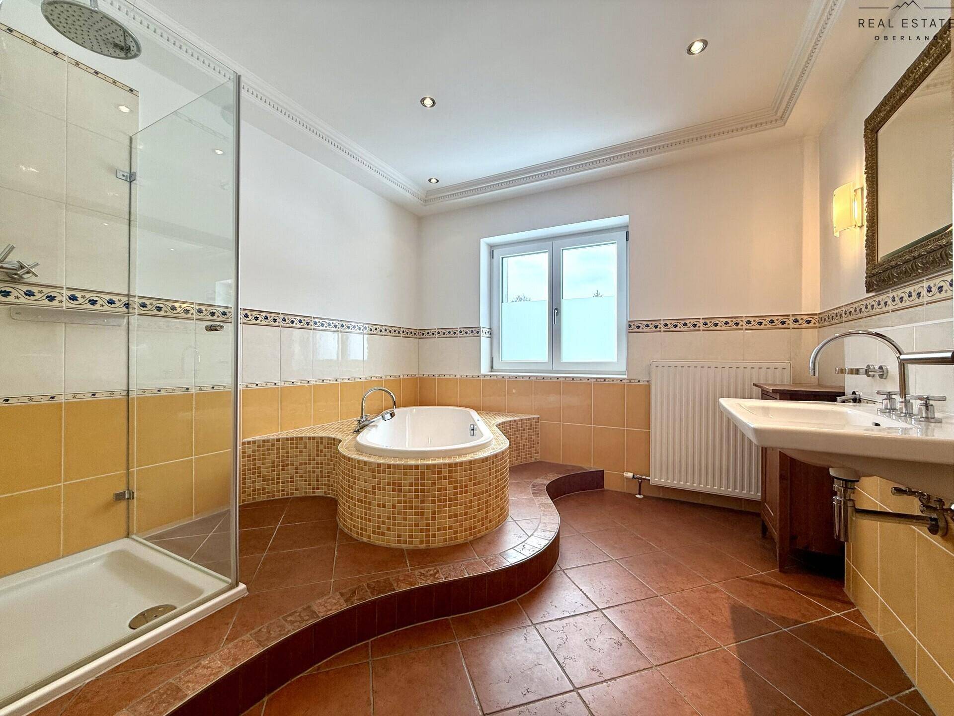 Geräumiges Badezimmer mit Terrakotta-Fliesen, Eckbadewanne, begehbarer Dusche und Fenster.