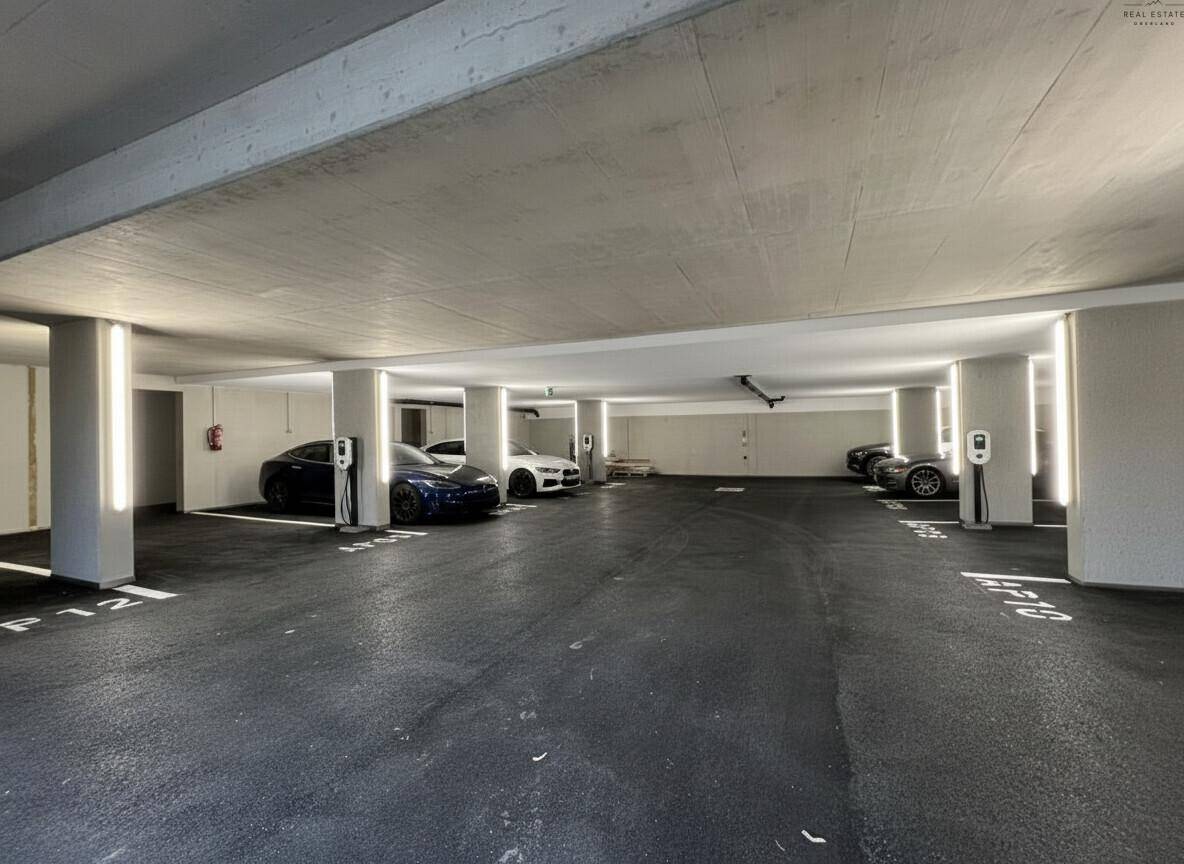 Geräumige Tiefgarage mit mehreren Stellplätzen und Ladestationen für Elektrofahrzeuge.