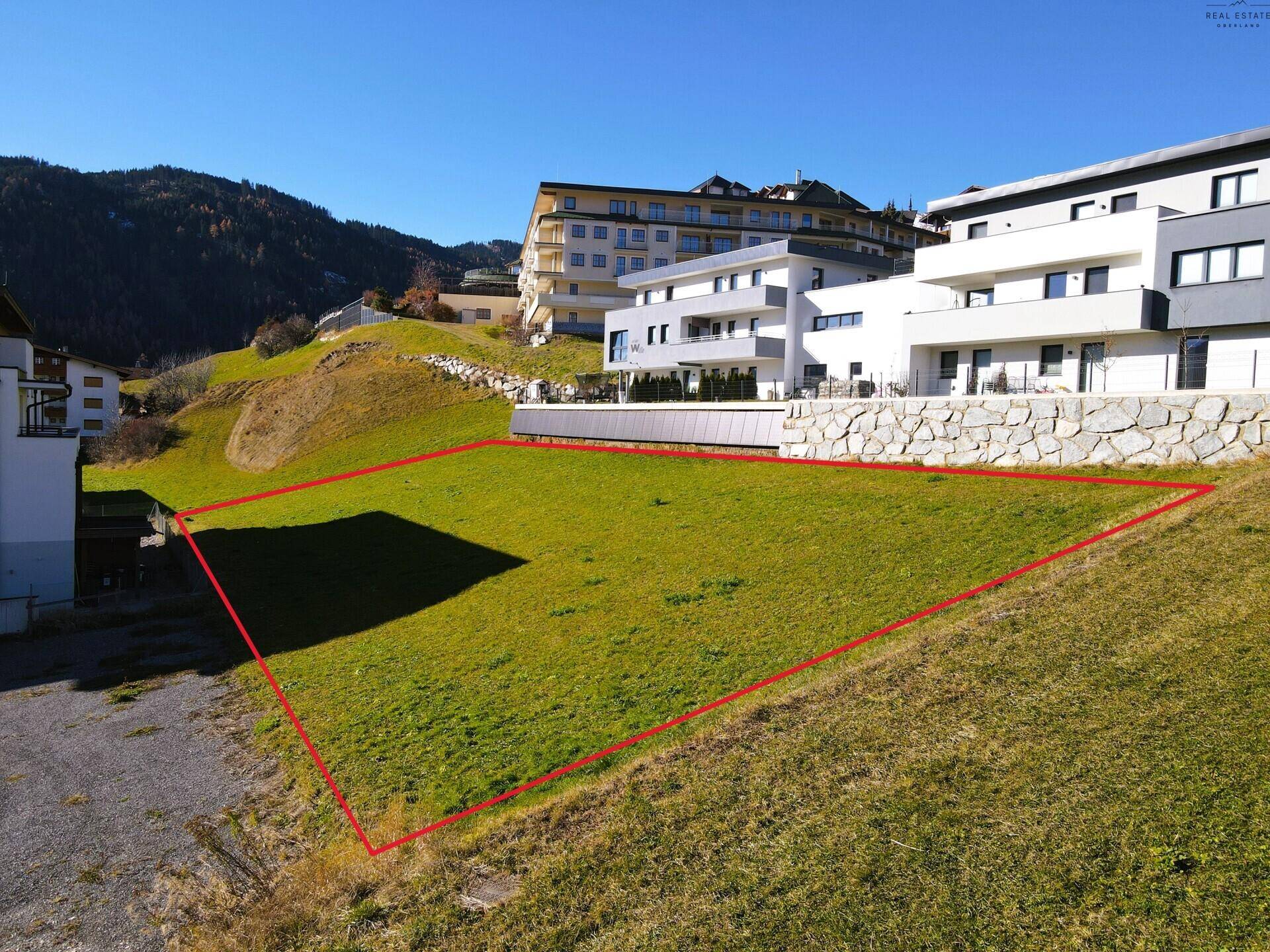 Übersicht des Baugrundstücks mit roter Markierung und umliegenden modernen Gebäuden.