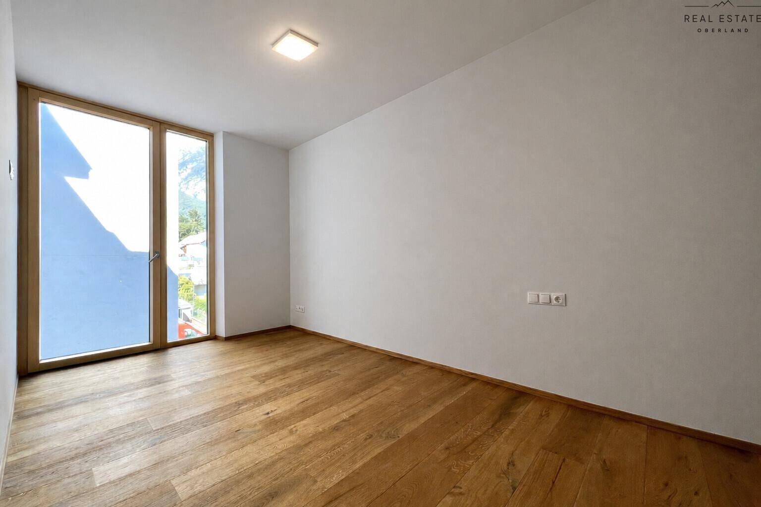 Geräumiges Schlafzimmer mit viel Tageslicht und hochwertigem Holzparkettboden.