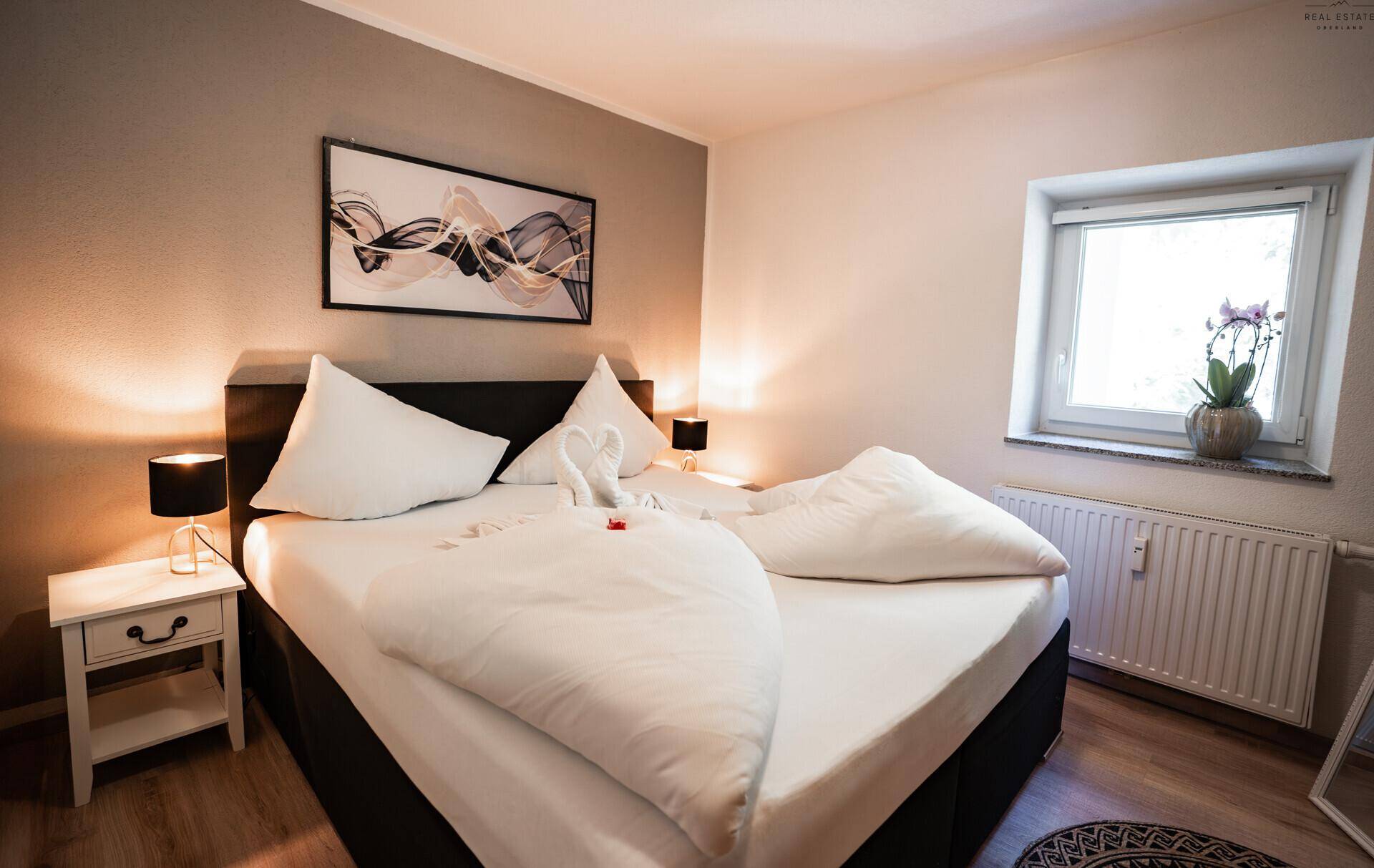 Schlafzimmer mit Doppelbett, Nachttisch und Kleiderschrank, hell und einladend.