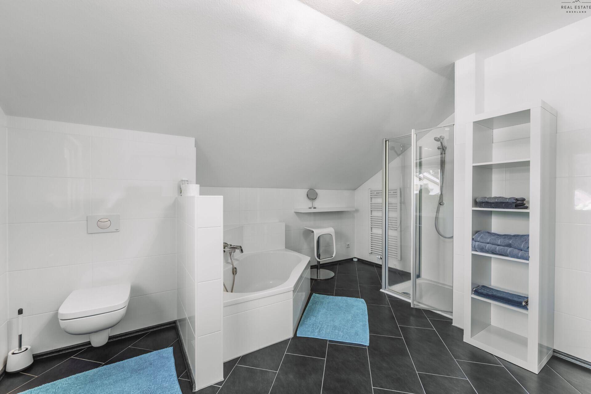 Modernes Badezimmer mit Dusche, Badewanne und beheiztem Handtuchhalter im Dachgeschoss.