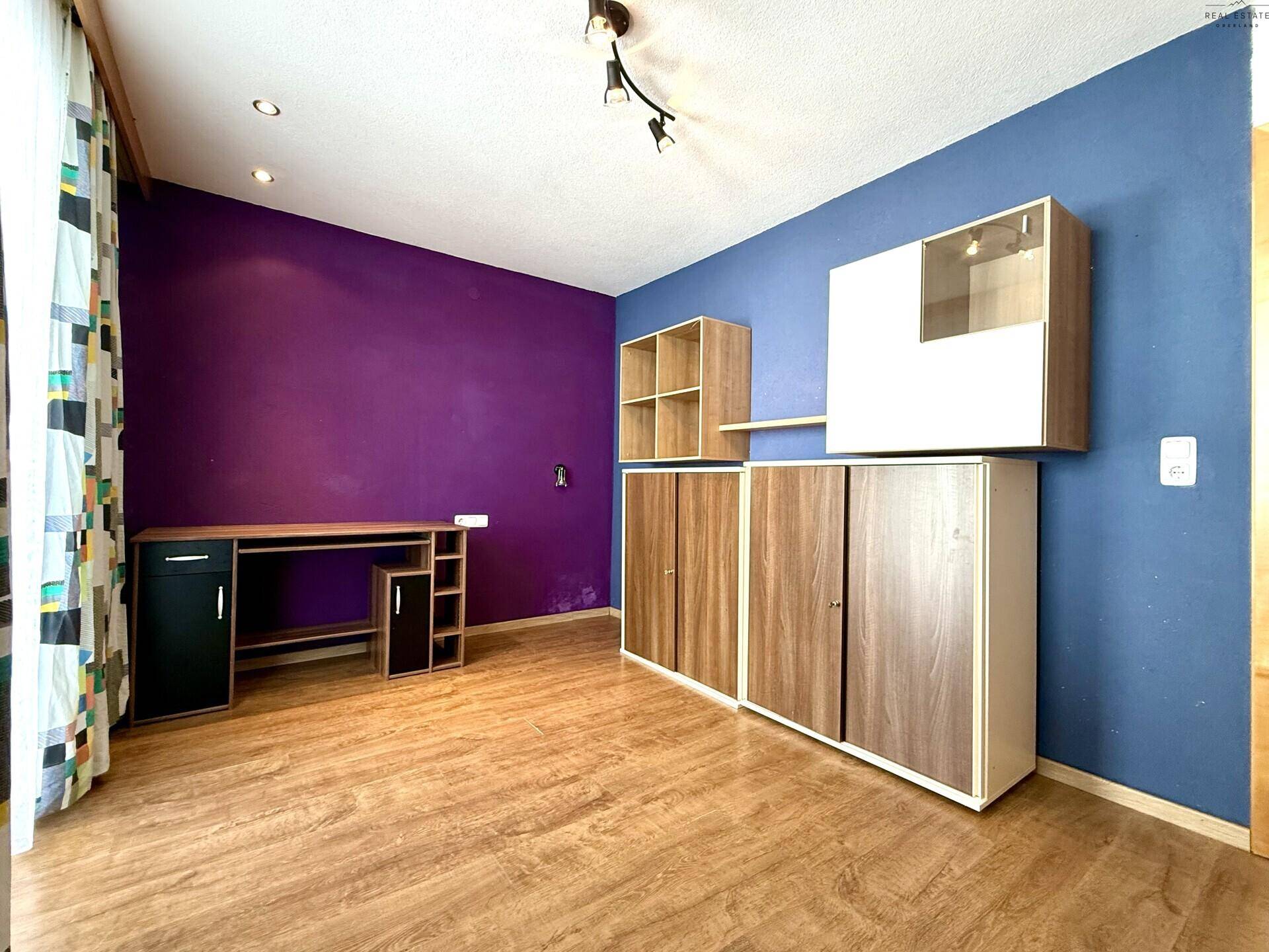 Arbeitszimmer mit farbigen Wänden, Schreibtisch und Holzschränken, bietet eine inspirierende Umgebung.