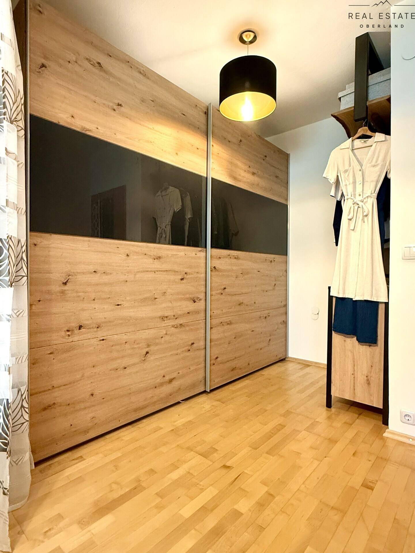 Geräumiger Kleiderschrank mit Holzfronten und Spiegeltüren im Schlafzimmer.