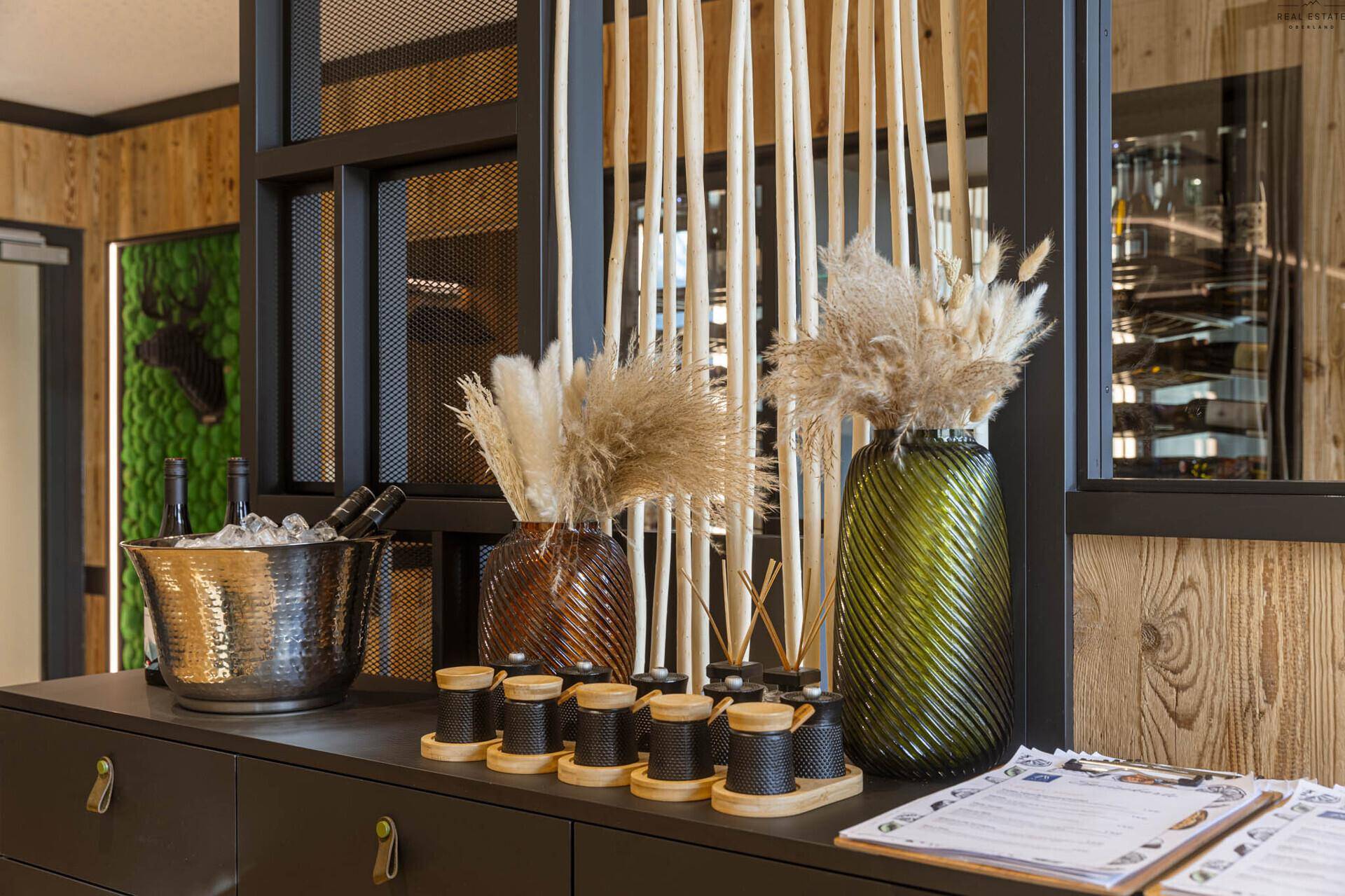 Detailansicht der eleganten Dekoration auf einem Sideboard, mit Pampasgras und einem Weinkühler.