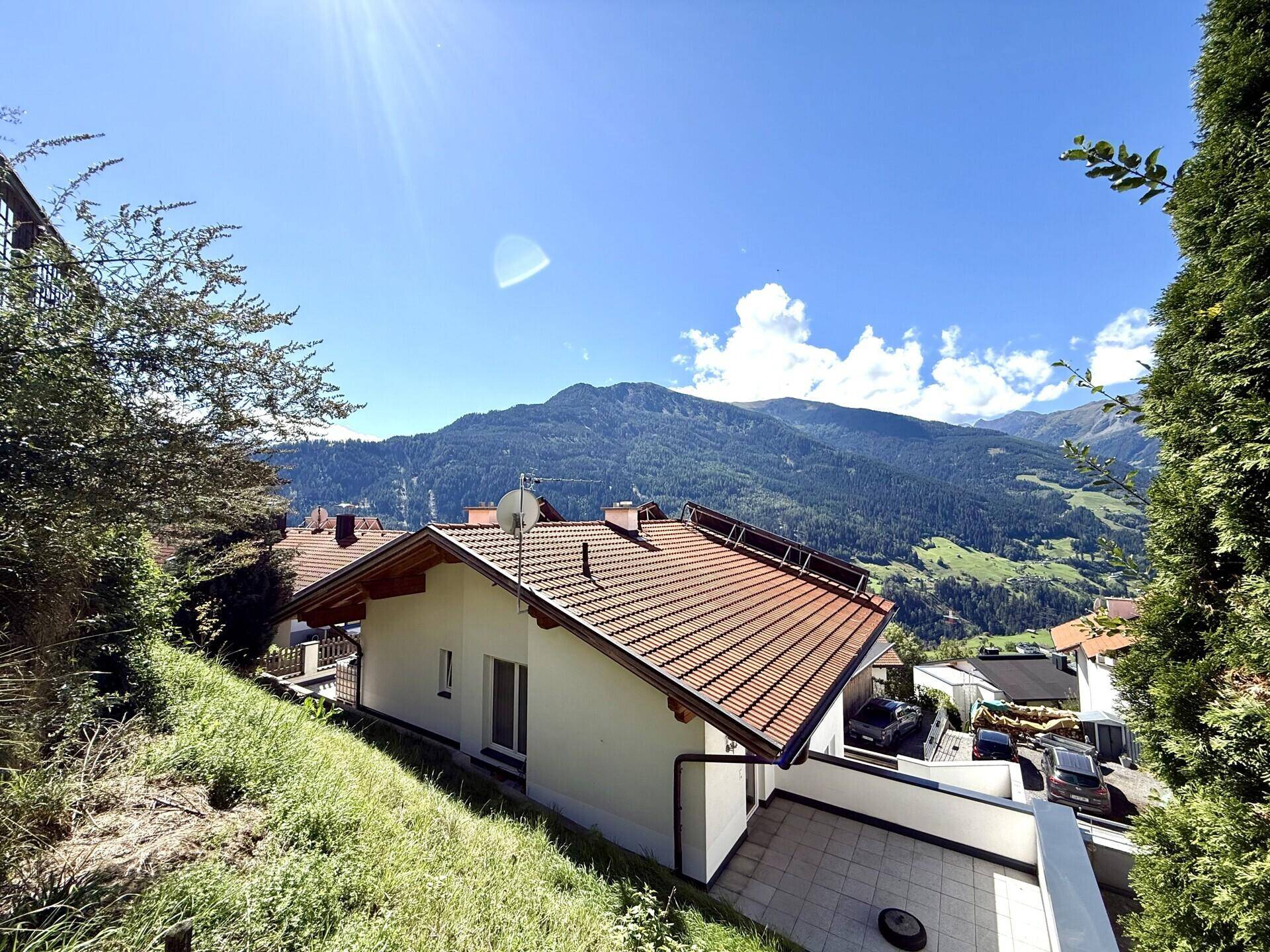 Außenansicht des Hauses mit Satteldach und Bergblick in sonniger Lage, umgeben von Natur.