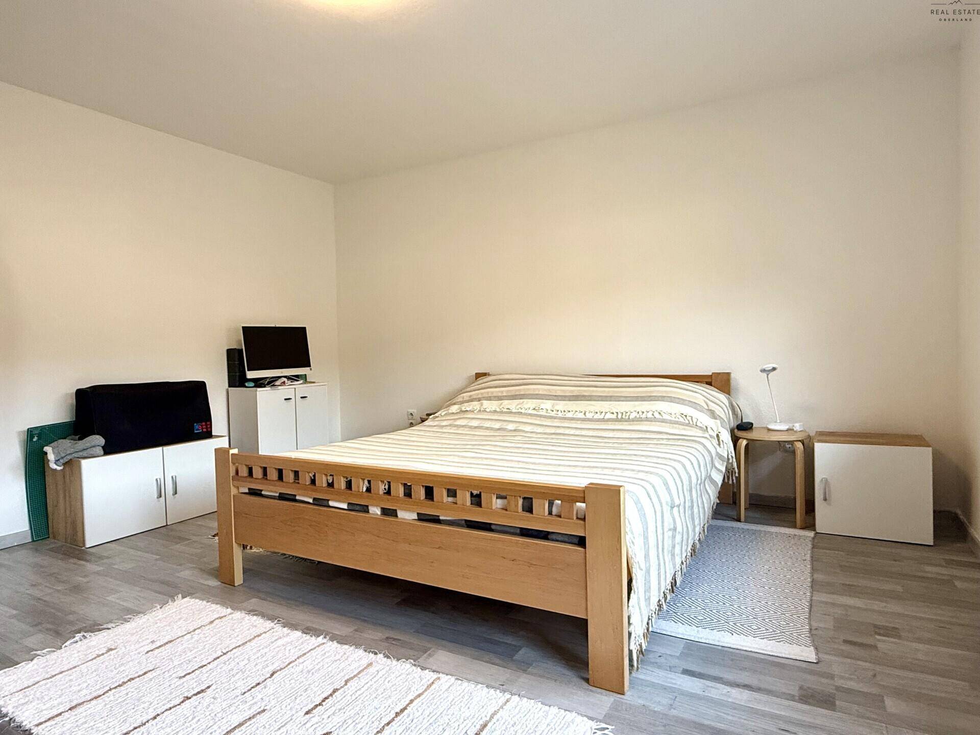 Geräumiges Schlafzimmer mit Doppelbett, Nachttischen und schlichten Möbeln.