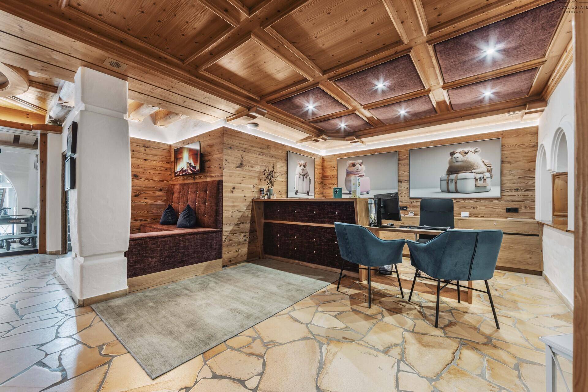 Warmer Empfangsbereich mit Holzvertäfelung, bequemen Sitzgelegenheiten und Rezeptionstresen.