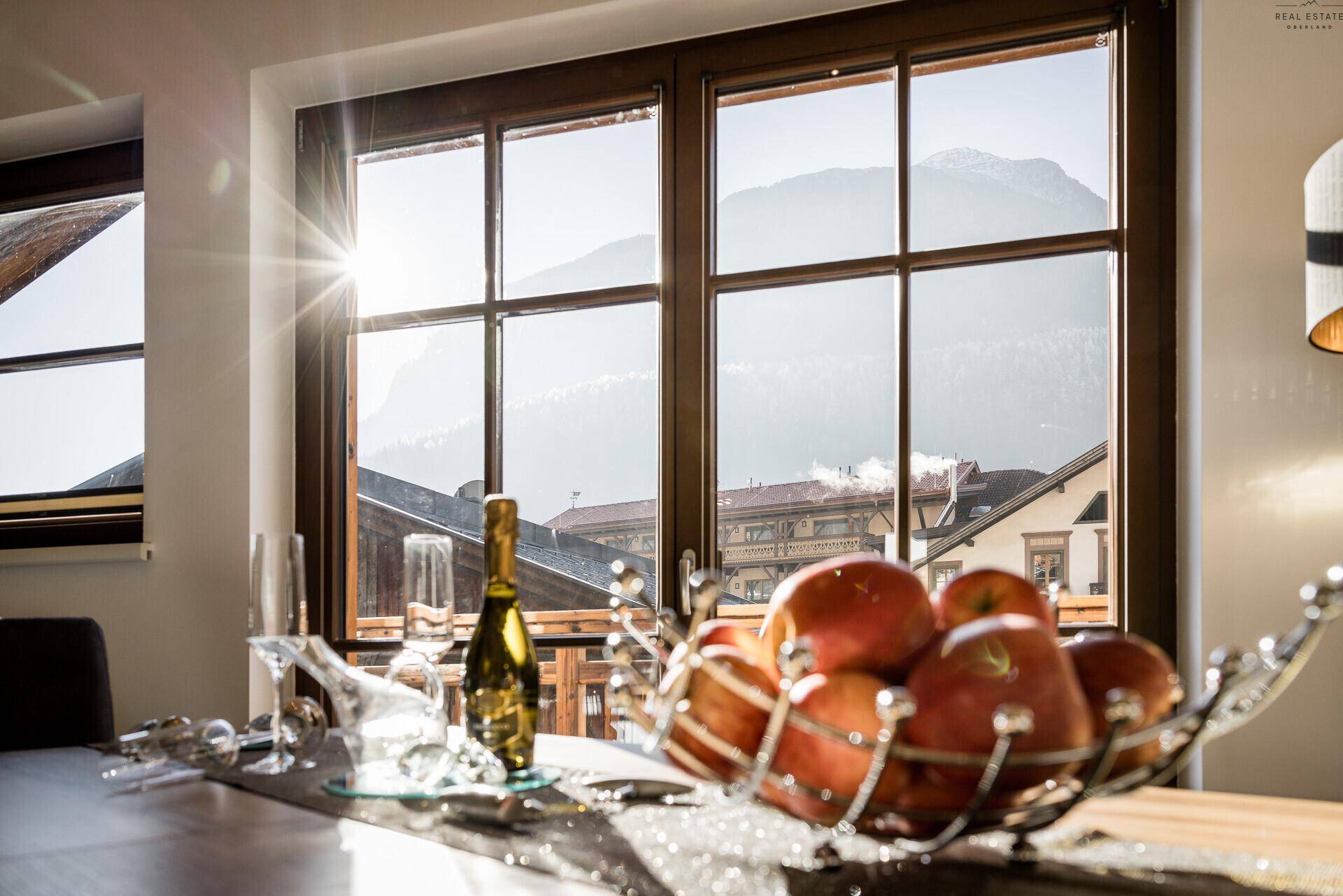 Sonnenverwöhnter Blick aus dem Fenster auf die umliegende Berglandschaft.