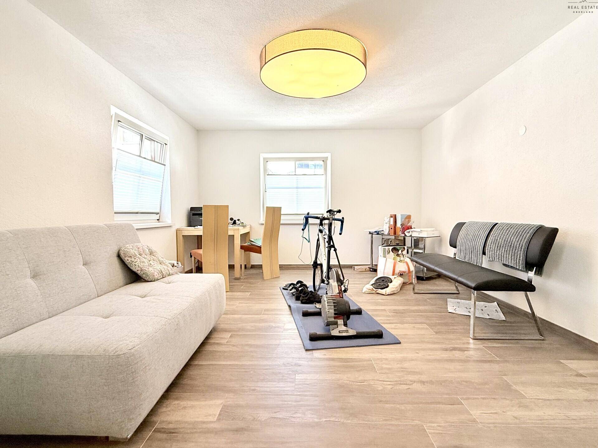 Vielseitiger Raum, eingerichtet als Fitnessbereich mit Sofa und Schreibtisch.