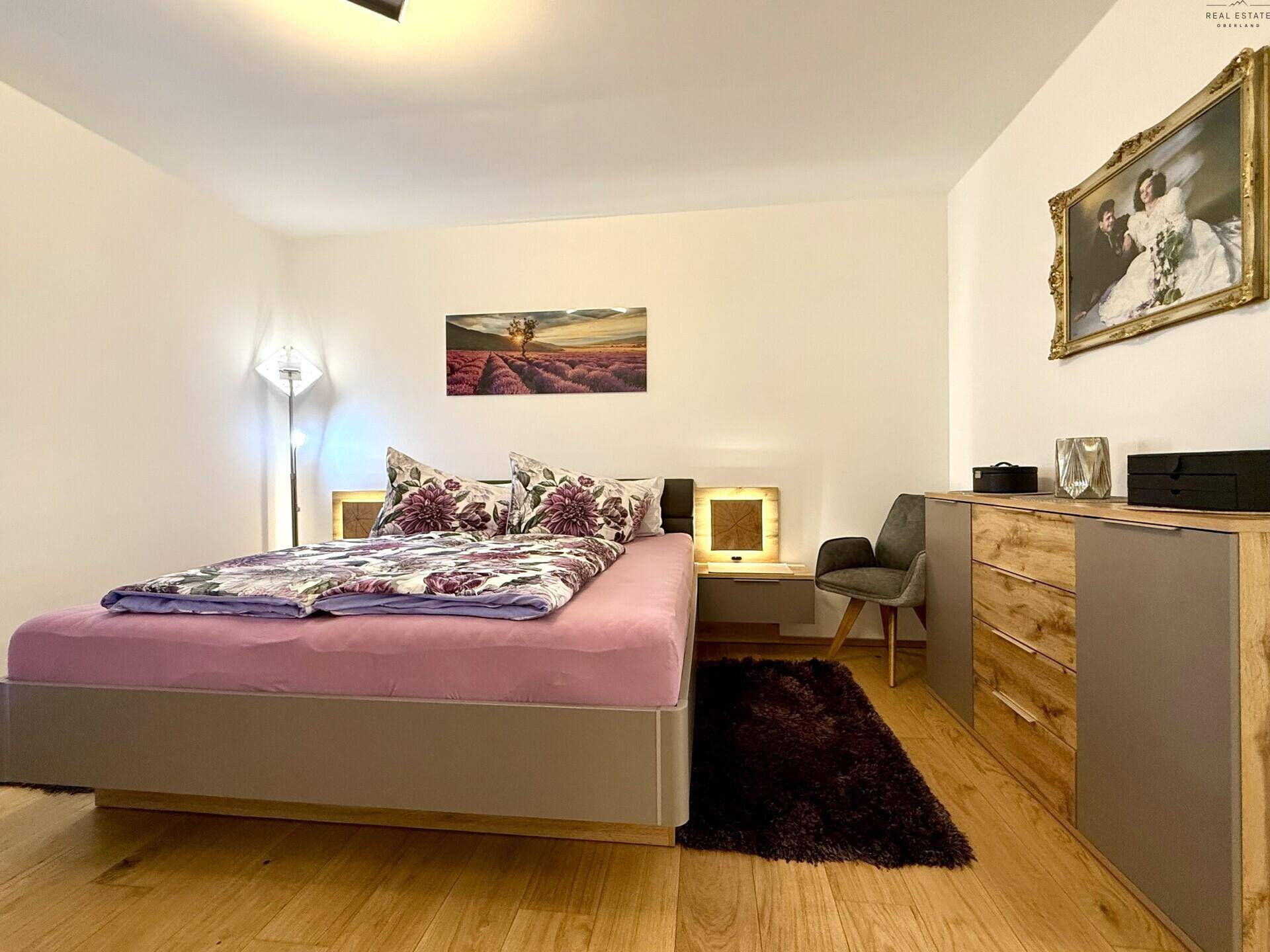 Modernes Schlafzimmer mit Doppelbett, Holzboden und stilvollen Nachttischen.