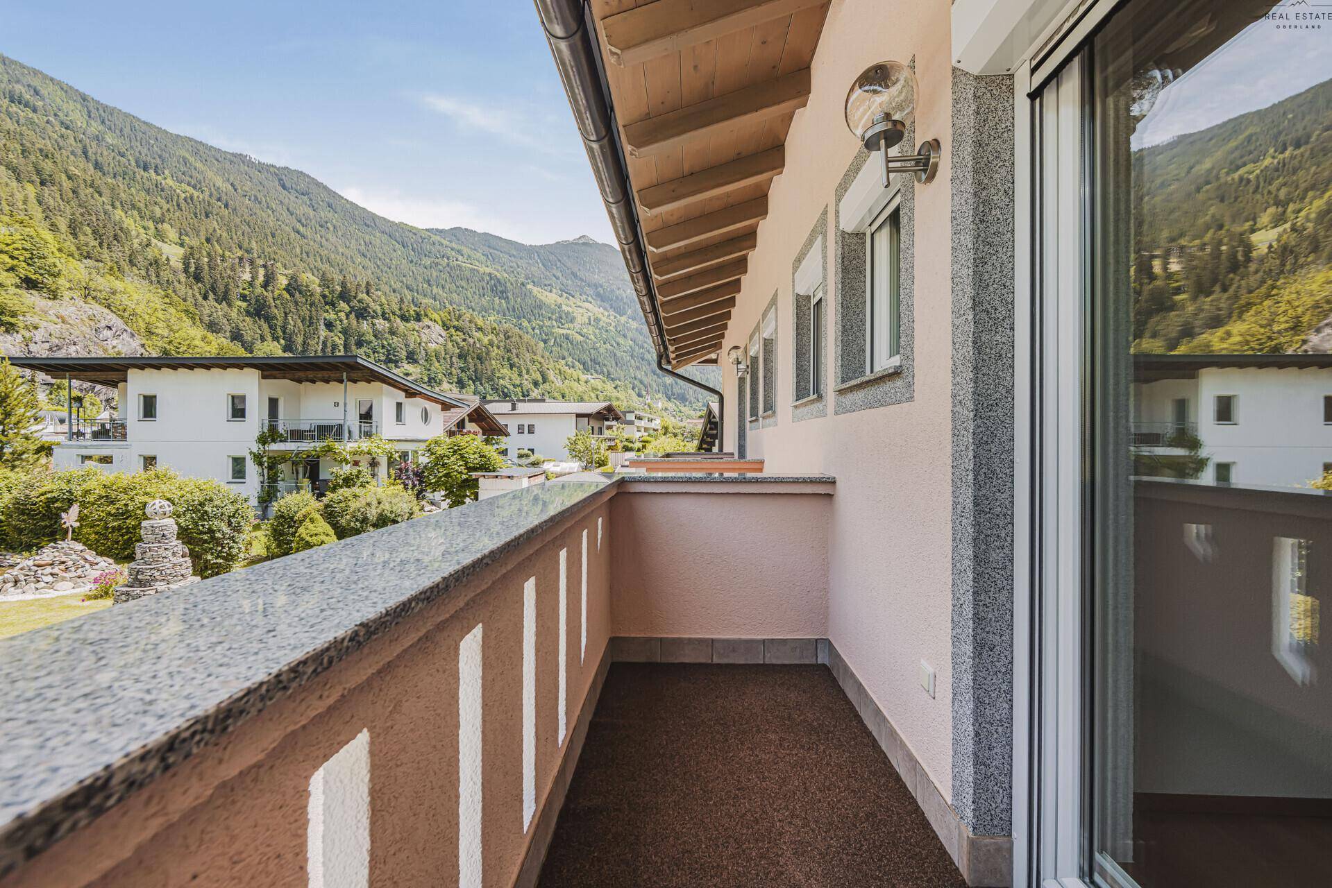 Geräumiger Balkon mit Blick auf die Nachbarhäuser und die grüne Umgebung.