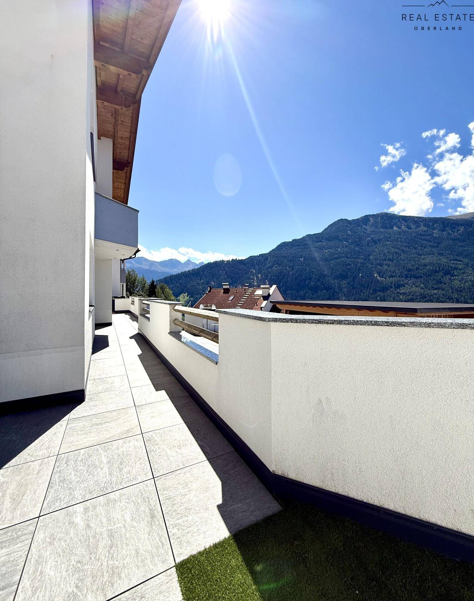 Weitläufige Terrasse mit Fliesenboden und atemberaubendem Panoramablick auf die Berge.